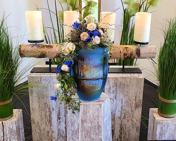 Urne auf Traueralter mit Blumenschmuck