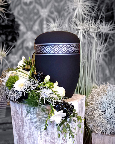 Urne auf Traueralter mit Blumenschmuck