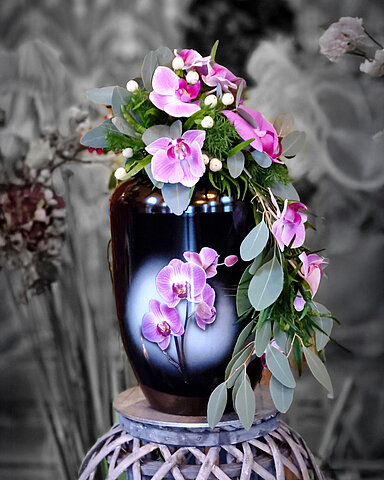 Urne auf Traueralter mit Blumenschmuck