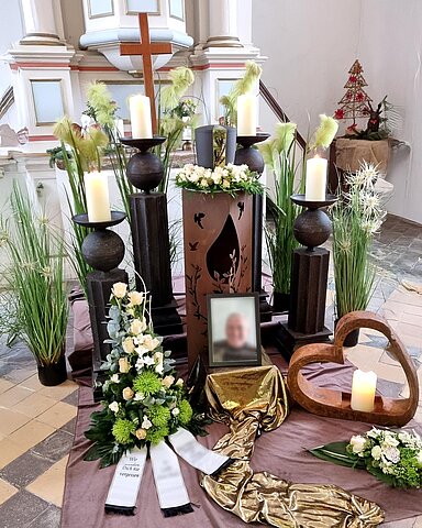 Urne auf Traueralter mit Blumenschmuck